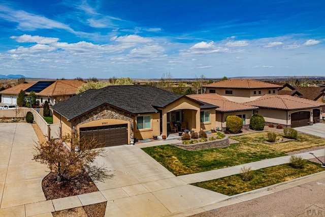 ranch-style house with a garage, fence, stucco siding, a front lawn, and driveway