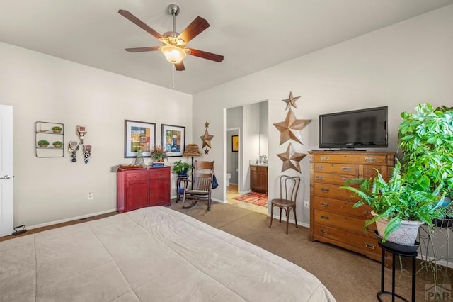bedroom with baseboards, carpet flooring, ceiling fan, and connected bathroom