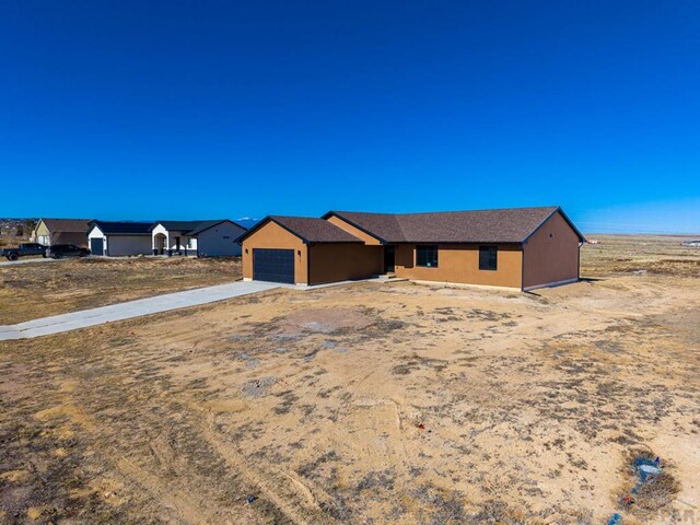 view of front of home featuring concrete driveway, an attached garage, and stucco siding