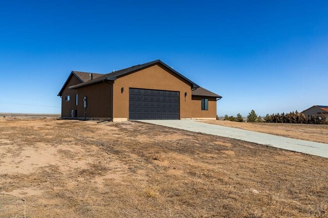 view of home's exterior featuring an attached garage, concrete driveway, and stucco siding