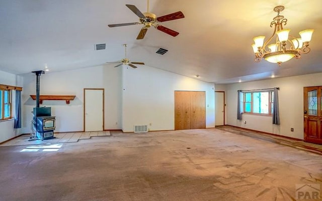 5207 N Creek Rd, Beulah, CO 81023 - unfurnished living room featuring a wood stove, a ceiling fan, light colored carpet, lofted ceiling, and a chandelier