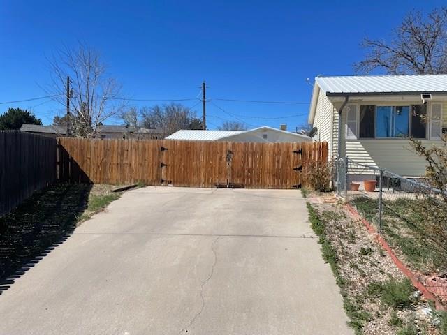 view of side of property with metal roof and fence private yard