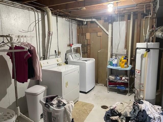 unfinished basement featuring water heater and washer and clothes dryer