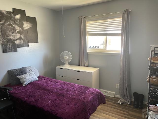 bedroom with visible vents and wood finished floors