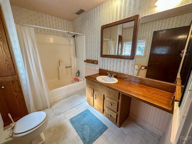 bathroom with wallpapered walls, shower / bath combo, visible vents, toilet, and vanity