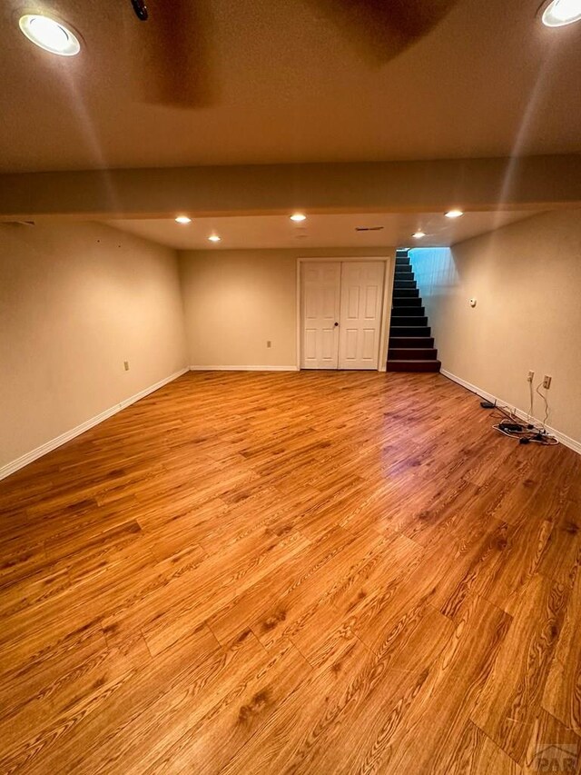 finished basement with light wood finished floors, baseboards, stairway, and recessed lighting