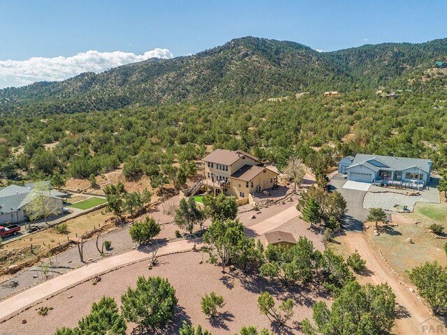 birds eye view of property featuring a mountain view and a wooded view