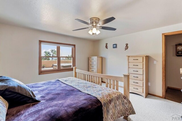 carpeted bedroom with ceiling fan and baseboards