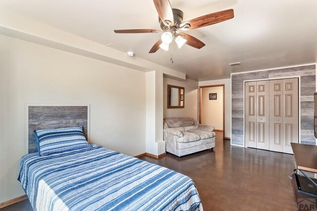 bedroom with baseboards, visible vents, a ceiling fan, concrete flooring, and a closet