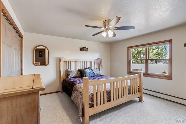 bedroom with baseboards, light colored carpet, ceiling fan, baseboard heating, and a textured ceiling