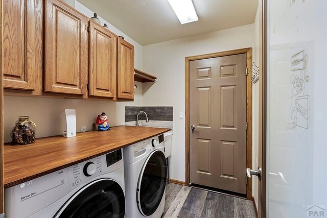 laundry room featuring cabinet space, dark wood-style floors, a sink, and independent washer and dryer