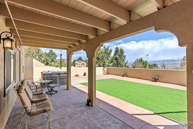 view of patio / terrace with outdoor dining area, a fenced backyard, and a mountain view