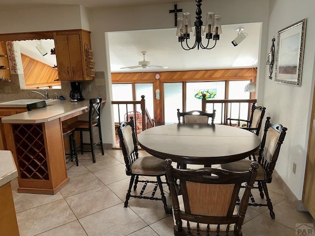 dining space featuring an inviting chandelier, light tile patterned floors, and baseboards