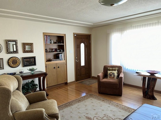 interior space featuring light wood finished floors, plenty of natural light, baseboards, and a textured ceiling