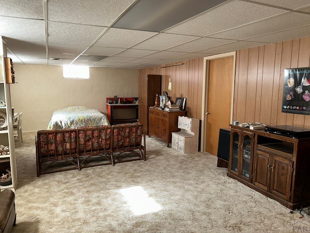 carpeted bedroom with wood walls and a drop ceiling