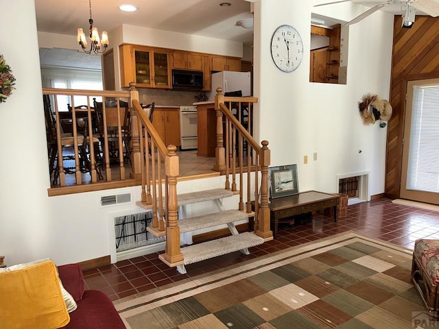 staircase featuring baseboards, an inviting chandelier, visible vents, and tile patterned floors