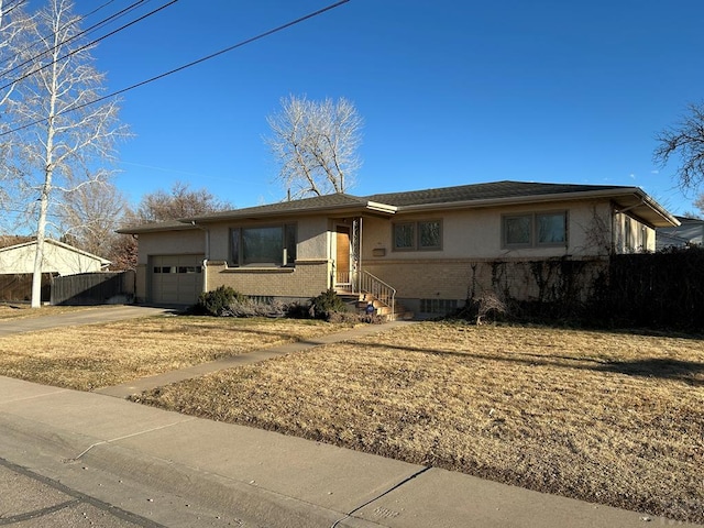 ranch-style home with brick siding, stucco siding, concrete driveway, fence, and a garage