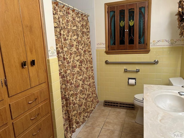 full bath with toilet, a shower with shower curtain, visible vents, wainscoting, and tile patterned floors