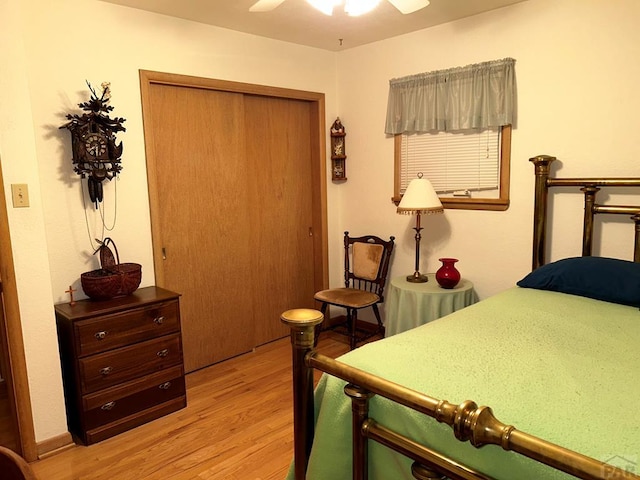 bedroom featuring light wood-style floors, a ceiling fan, and a closet