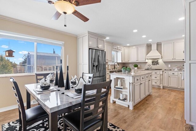 kitchen with premium range hood, a kitchen island, stainless steel refrigerator with ice dispenser, open shelves, and light wood finished floors