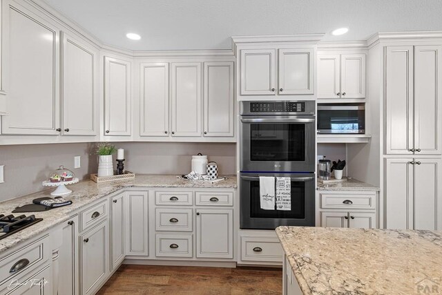 kitchen featuring appliances with stainless steel finishes, recessed lighting, dark wood-style flooring, and white cabinets