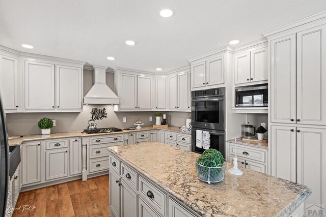 kitchen with light wood-style flooring, recessed lighting, premium range hood, white cabinets, and appliances with stainless steel finishes