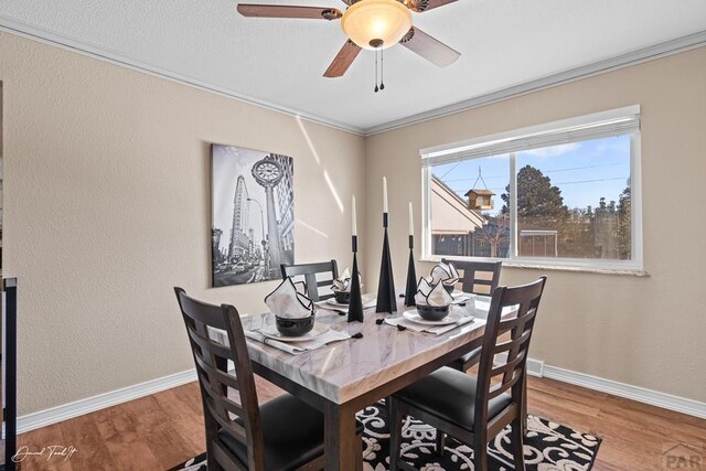 dining area with ornamental molding, baseboards, and wood finished floors