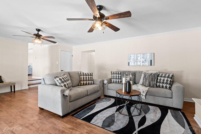 living room with baseboards, ornamental molding, ceiling fan, and wood finished floors