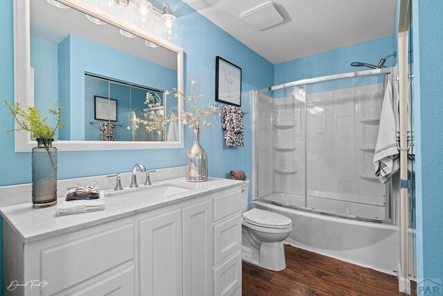 full bathroom featuring toilet, enclosed tub / shower combo, wood finished floors, and vanity