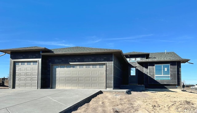 prairie-style house featuring concrete driveway and an attached garage