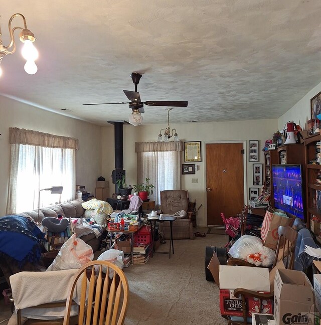 living area featuring carpet, ceiling fan, and a textured ceiling