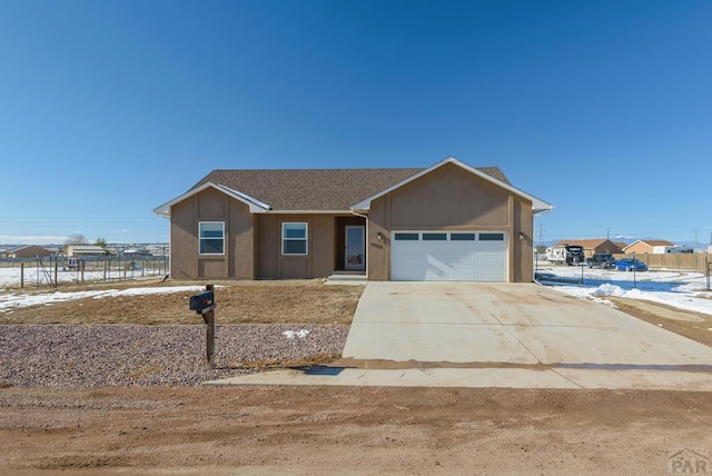 view of front of house featuring a garage, a shingled roof, fence, concrete driveway, and stucco siding