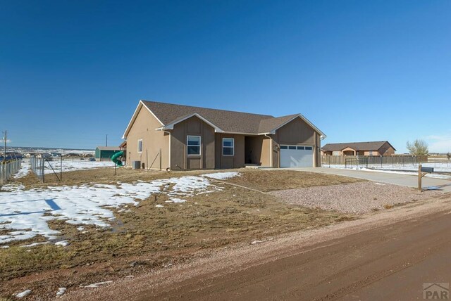 view of front of house with an attached garage, fence, and concrete driveway