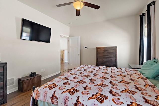 bedroom with baseboards, wood finished floors, visible vents, and a ceiling fan