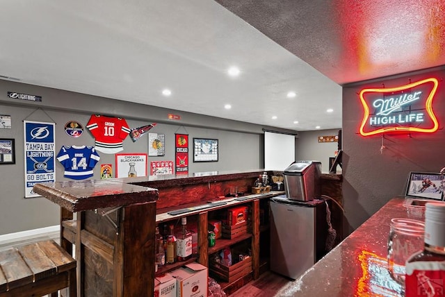 interior space featuring a dry bar, stainless steel fridge, wood finished floors, and recessed lighting