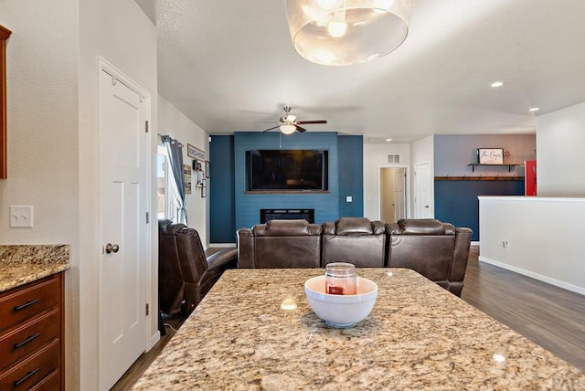 dining space with dark wood-style floors, visible vents, baseboards, and a ceiling fan