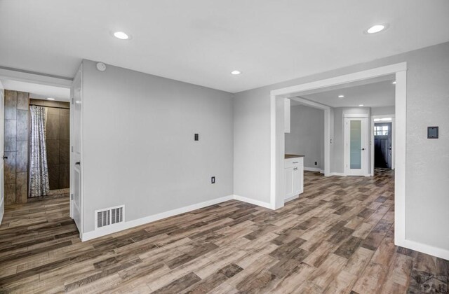 spare room featuring recessed lighting, wood finished floors, visible vents, and baseboards