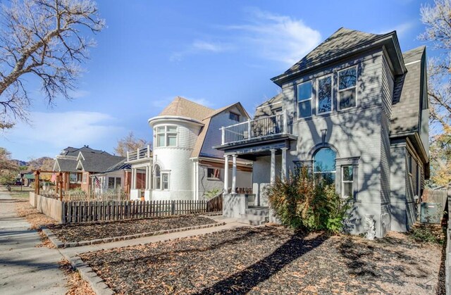 view of front of home with a balcony and a fenced front yard