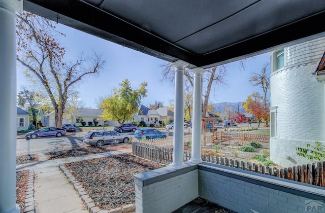 view of patio with covered porch, a residential view, fence, and a mountain view