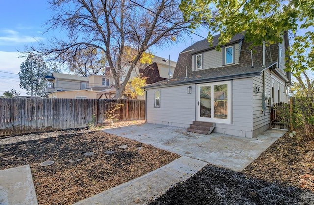 back of property featuring entry steps, a patio area, a fenced backyard, and a gambrel roof