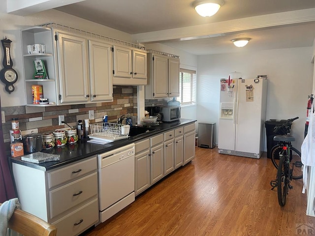 kitchen featuring light wood-style flooring, open shelves, dark countertops, white appliances, and decorative backsplash