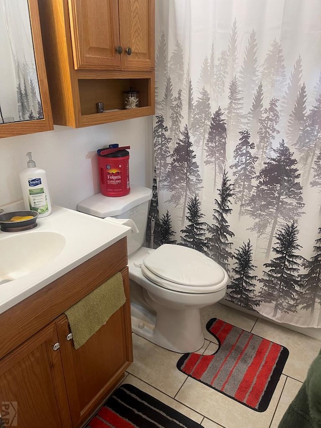 bathroom featuring tile patterned flooring, a shower with curtain, toilet, and vanity