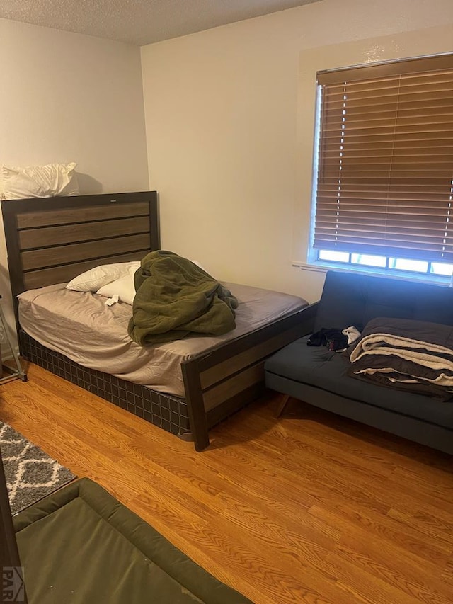 bedroom featuring wood finished floors and a textured ceiling