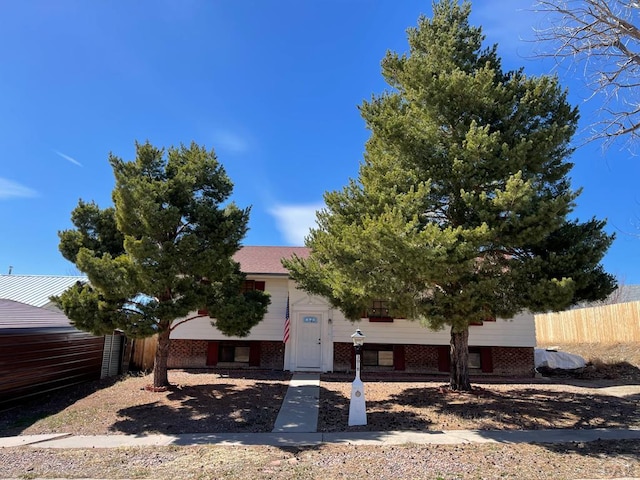 bi-level home with brick siding and fence