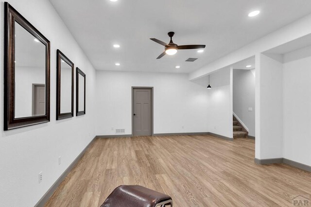 unfurnished living room featuring stairs, ceiling fan, recessed lighting, and light wood-style floors