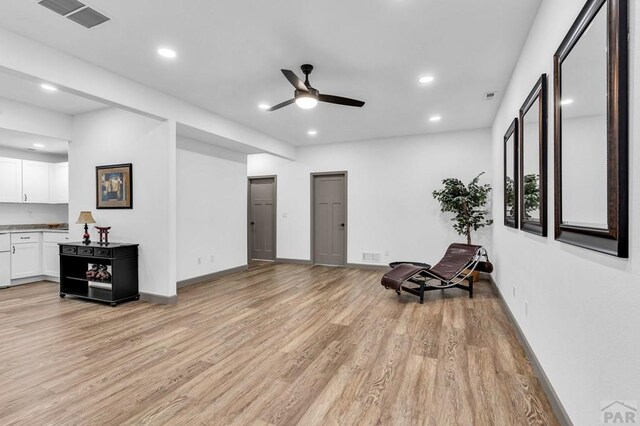 living area featuring visible vents, baseboards, light wood-style flooring, ceiling fan, and recessed lighting