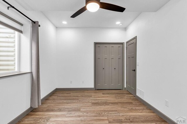 spare room with light wood finished floors, recessed lighting, visible vents, a ceiling fan, and baseboards