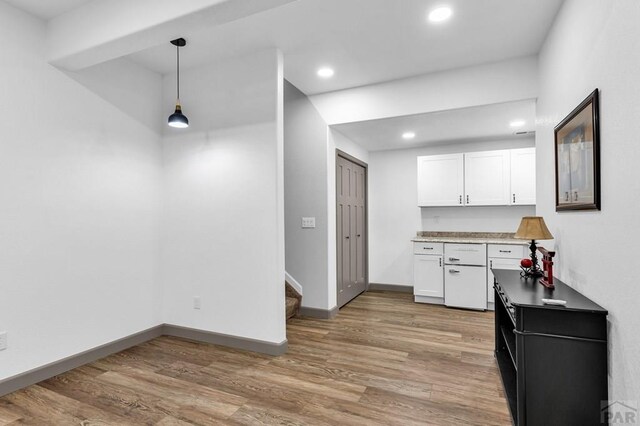 kitchen featuring recessed lighting, baseboards, white cabinets, light wood finished floors, and decorative light fixtures