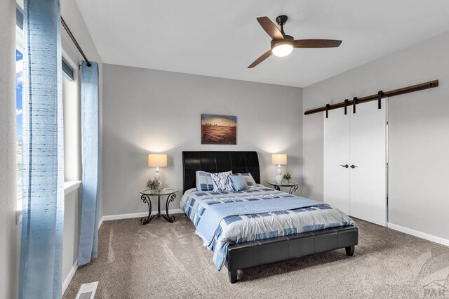 carpeted bedroom with visible vents, ceiling fan, and baseboards