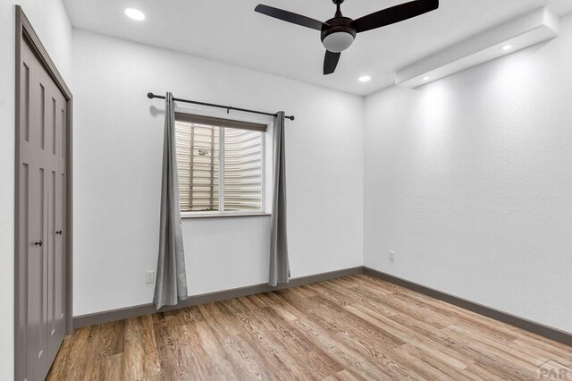 empty room featuring light wood-style flooring, baseboards, ceiling fan, and recessed lighting